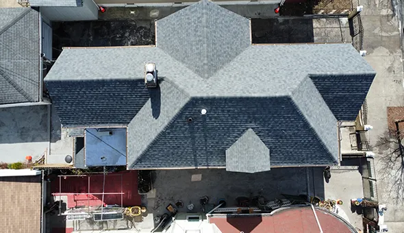 Aerial view of gray architectural asphalt shingle roof installation on multiple residential houses in Queens, NY.