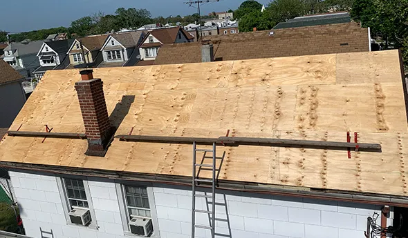 Construction workers installing wooden roof decking on a residential house in Manhattan, NY.